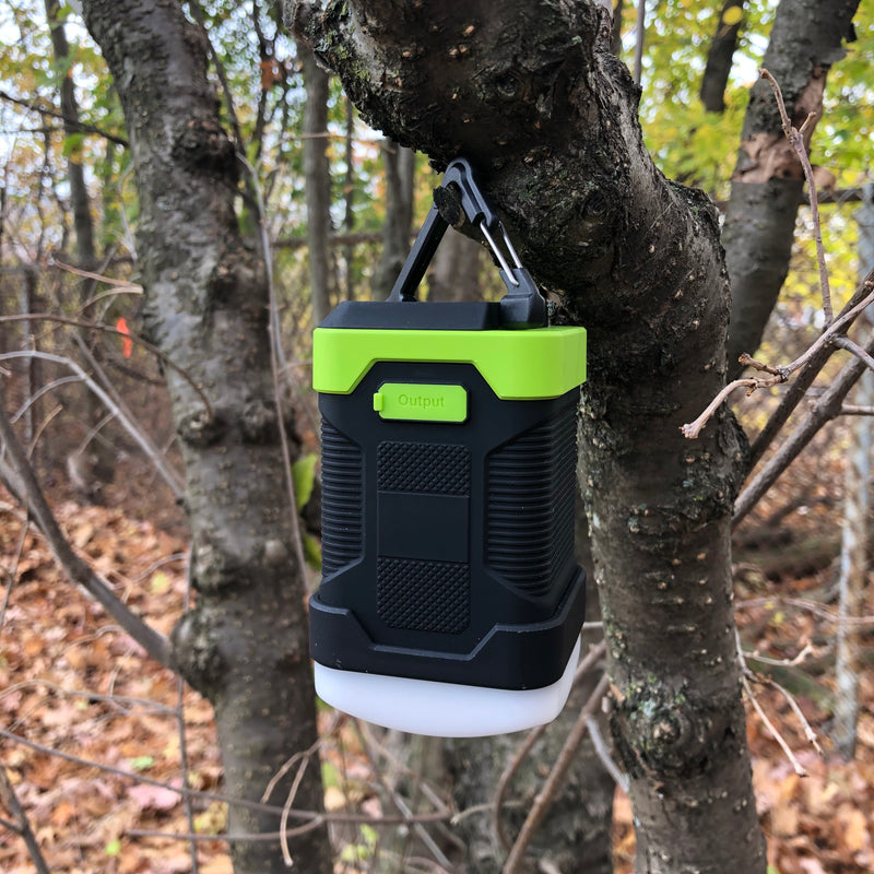2 in 1 Waterproof Camping Lantern & Rechargeable Power Bank Combo is hanging on a tree.